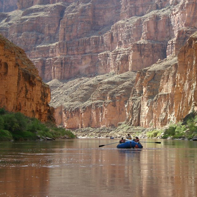 Raft floating down the river in a steep-sided canyon