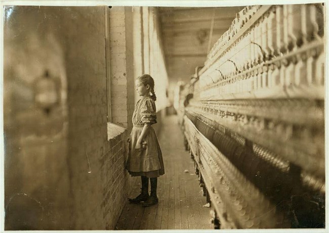 Young spinner looks out a window