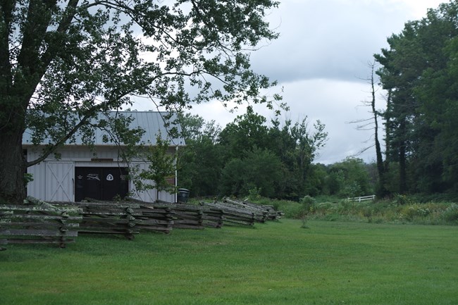 Building with wooden fence and grassy meadow