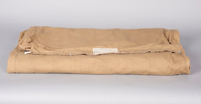 Folded khaki colored air mattress