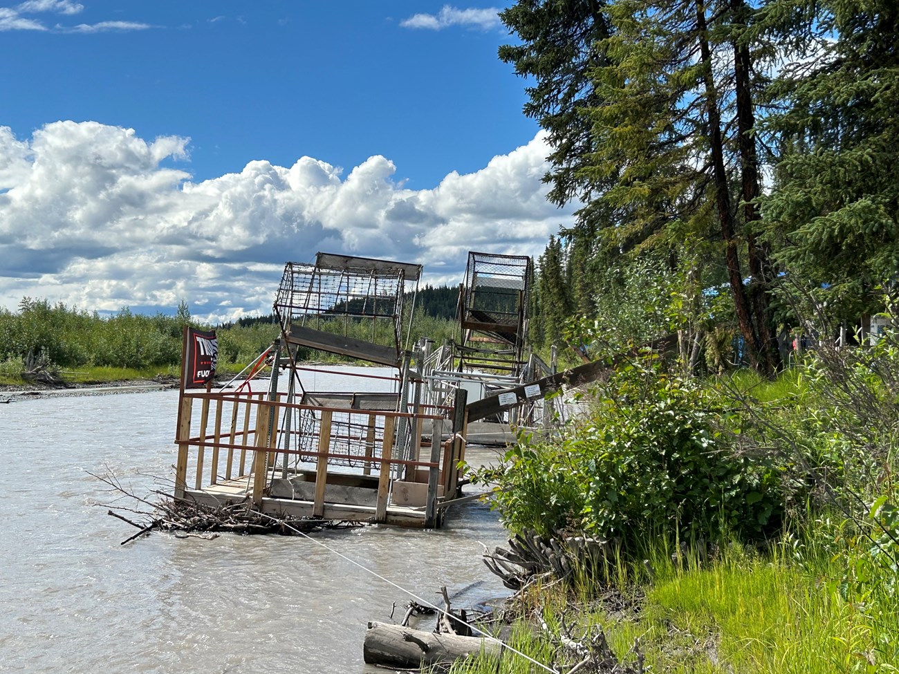 Two fish wheels turning in the Copper River near the bank