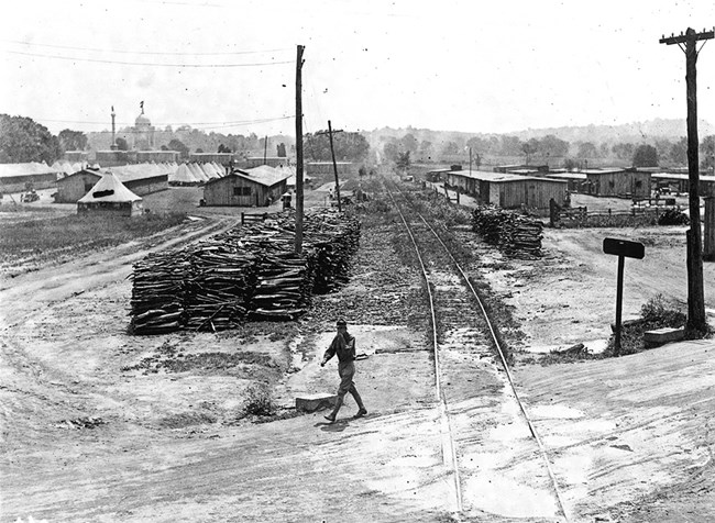 A black and white photo showing tents and structures on a large field