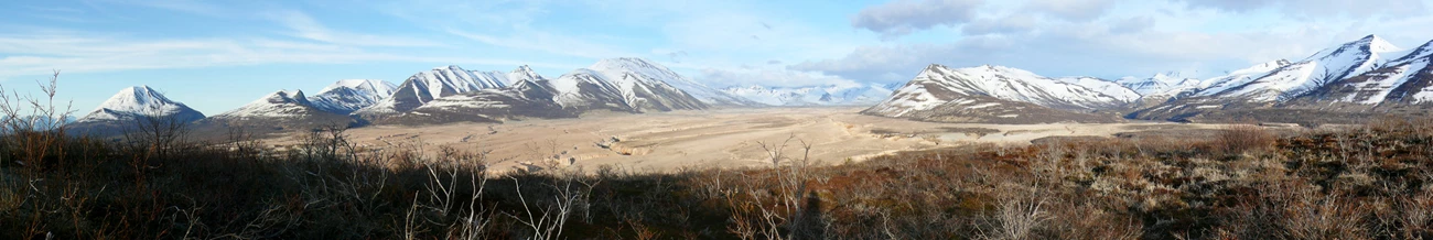 A volcanic valley under snow-covered mountains, seen from the overlook