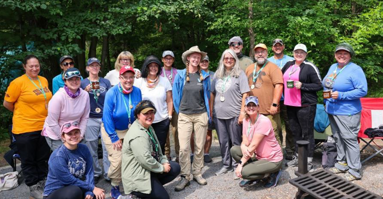 Photograph of a group of teachers posing with trees in the background.