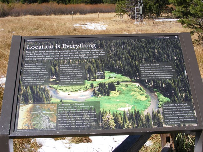 An interpretive sign at Devils Postpile National Monument explains why the location of the weather station in Soda Springs Meadow is important. A photo of the meadow and the river winding through it is on the sign along with text.