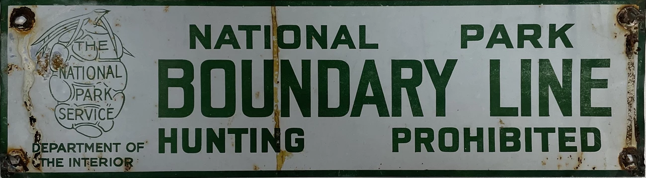 rectangular white sign with green letters and sequoia cone