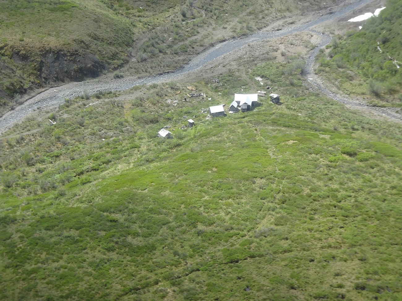 An aerial view of mining sites on the tundra near a river.