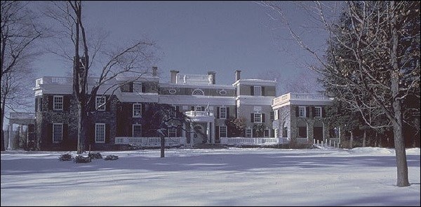 Large brick house covered in snow.