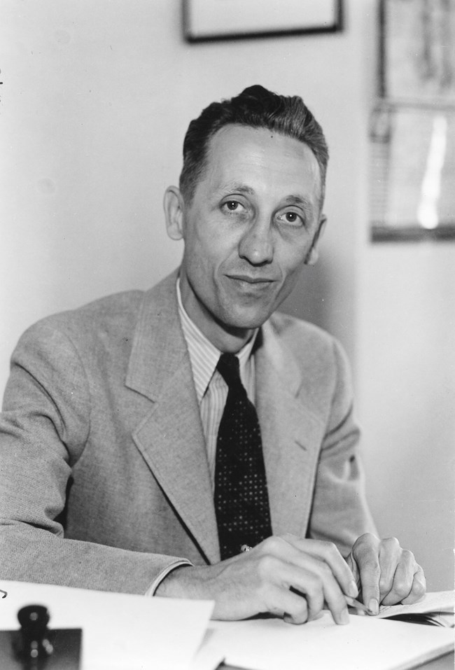 Man sitting at desk looking towards camera