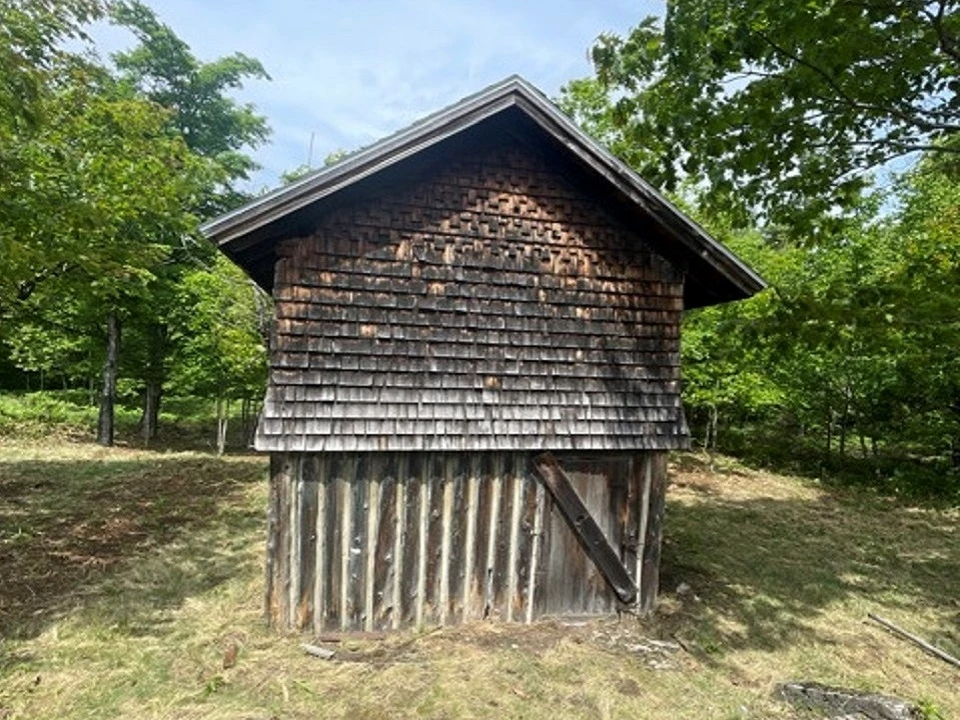 Wood sided historic barn with vegetation close in