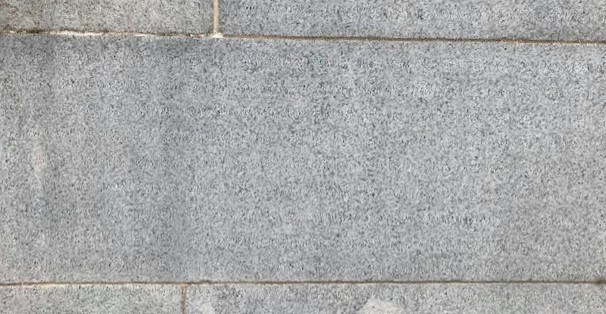 Close-up of a granite block with thin lines of mortar around it