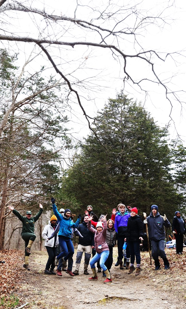 group of people in winter clothing posing for a photo on a trail