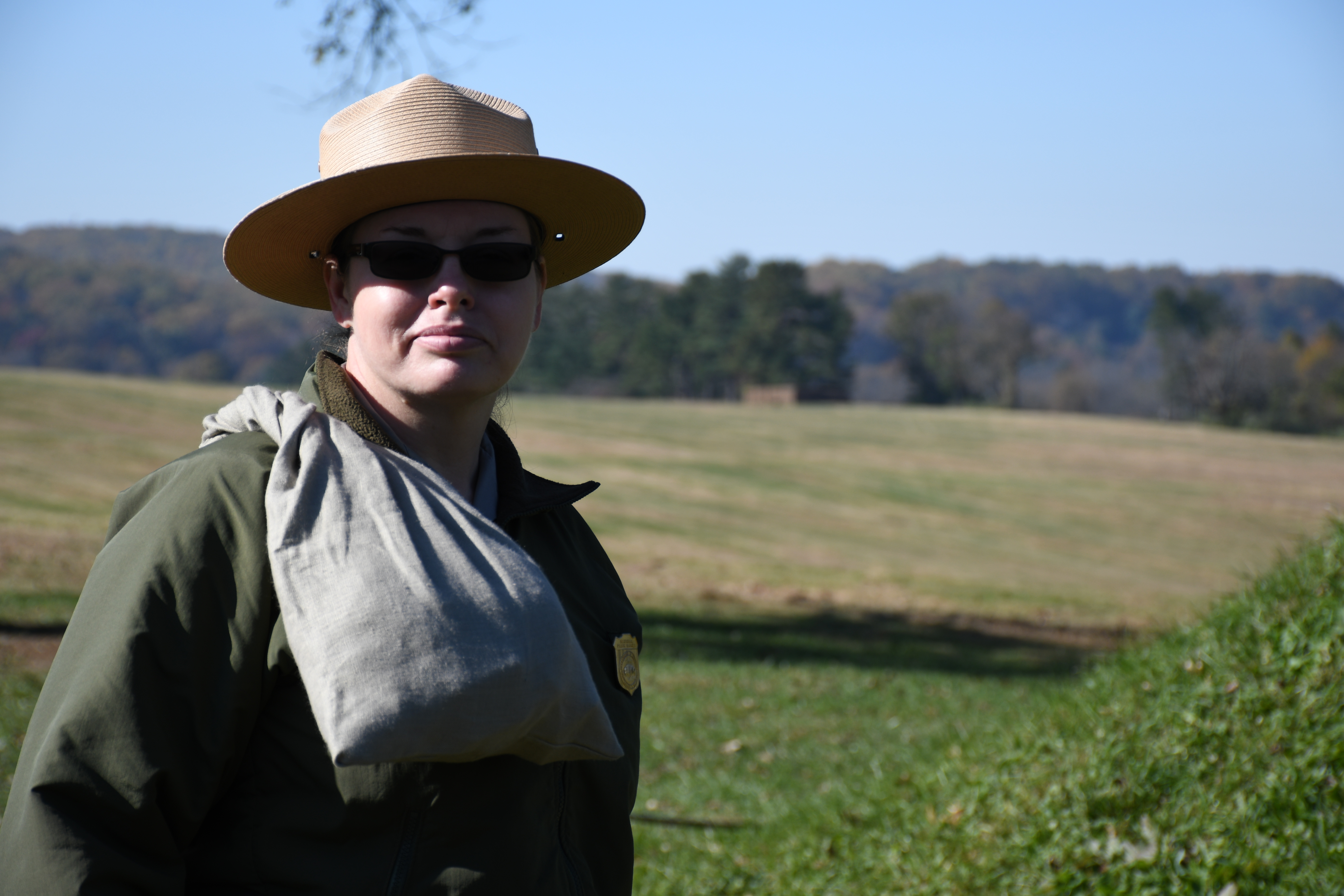 photograph, outdoors, a uniform park ranger carries a completed market wallet on her soldier