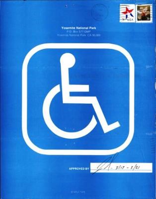 A large white international symbol of access (the wheelchair symbol) in front of a blue background. There are two stamps and Yosemite’s address at the top. The “Approved by” box is signed and shows the dates 3/19-3/21.