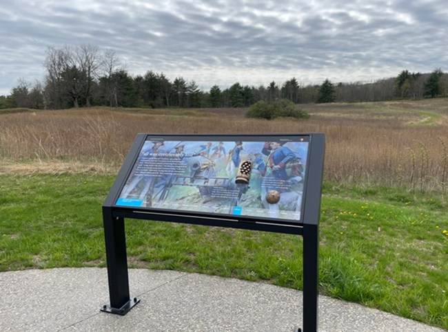 Interpretive panel at Tour Stop 5/Wheatfield where the 2nd Battle of Saratoga started. Incorporated bronze tactile features of a case shot canister and a cannon ball.