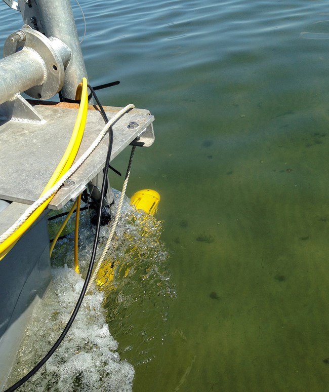 Sonar equipment on the front of the boat, over a sandy bottom