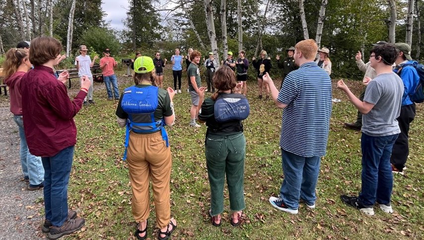 Photograph of group of people standing in a circle.